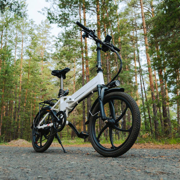 White electric bike on a forest path with trees in the background